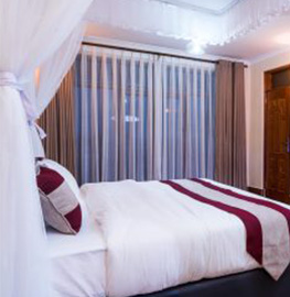 A single bed with sheer curtains